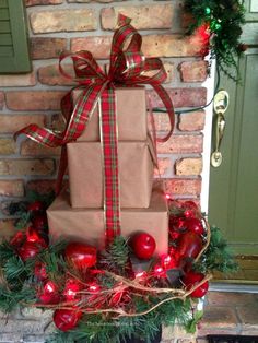 a christmas present wrapped in brown paper and tied with red ribbon sitting on top of a fireplace