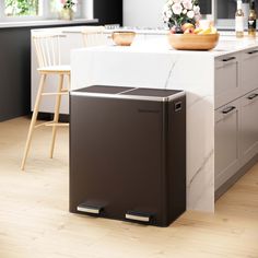 a black trash can sitting on top of a kitchen counter