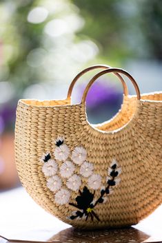 Natural straw tote with half-moon silhouette, wooden handle and embroidered pink and green floral design. The perfect summer day bag that goes with everything, she can be worn a beach bag or handbag. Dimensions: 15" W x 10" H Summer Straw Bag With Detachable Handle, Summer Crochet Bag With Detachable Top Handle, Spring Beach Bag With Round Handle, Eco-friendly Summer Straw Bag With Detachable Handle, Summer Vacation Straw Bag With Detachable Handle, Eco-friendly Straw Bag With Detachable Handle For Summer, Summer Crochet Tote Bag With Detachable Handle, Summer Straw Tote Bag With Detachable Handle, Summer Beach Bag With Detachable Handle In Natural Color