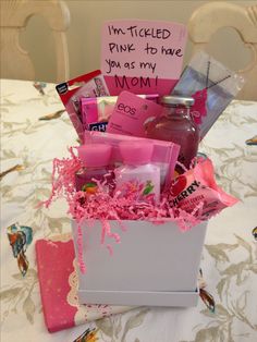 a pink gift box filled with personal care items on top of a white table cloth