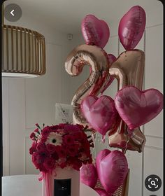 some balloons and flowers on a table in front of a mirror with the number twenty two