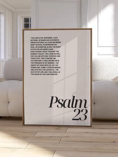 a white poster with the words paul 23 printed on it in front of a couch