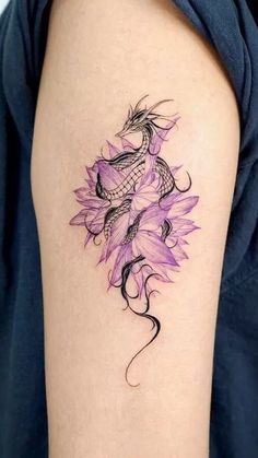 a woman's arm with a tattoo on it and flowers in the middle of her arm