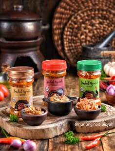 three jars of food sit on a wooden table next to some vegetables and other items