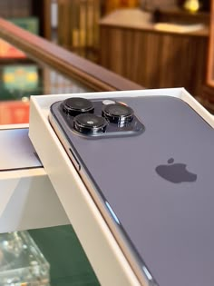 an iphone is sitting on top of a display case in a store with its lid open