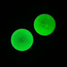 two green round lights glowing in the dark