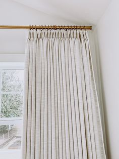 the curtain is closed in front of a window with white walls and windowsills