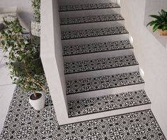 the stairs are decorated with black and white designs on them, as well as potted plants