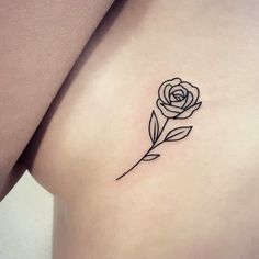 a small rose tattoo on the back of a woman's left shoulder and arm