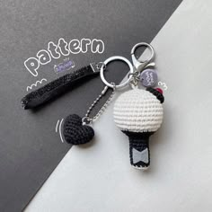 a crocheted keychain with a black and white ball hanging from it