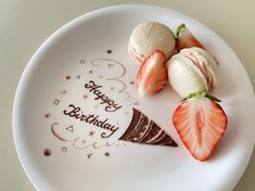 three strawberries on a plate with happy birthday written on it