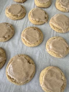 cookies with frosting and peanut butter on a sheet of parchment paper, ready to be baked