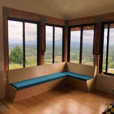 an empty room with large windows and blue cushions