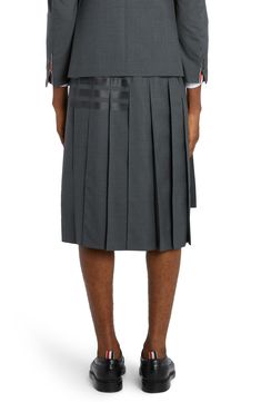 Tonal 4-Bar stripes skim the left side of this pleated wool skirt featuring a signature strap detail spanning the back waist. Tricolor grosgrain trim peeking beneath the high-low hem adds another classic Thom Browne touch. 23" center front length; 27" back length (size 2) Zip fly with hook-and-bar closure Cupro lining 100% wool Dry clean Made in Italy Men's Designer Clothing Solid Knee-length Pleated Skirt With Lining, Luxury Knee-length Lined Pleated Skirt, Knee-length Box Pleat Pleated Skirt, Luxury Knee-length Skirt With Pleated Hem, Thom Brown Skirt, High Low Hem, Wool Skirts, Designer Clothes For Men, Back Strap