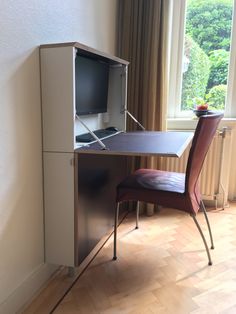 a desk with a computer monitor and chair next to it