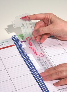 a person is holding a credit card next to a planner