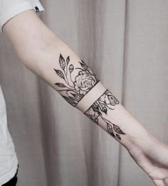 a woman's arm with flowers and leaves on it