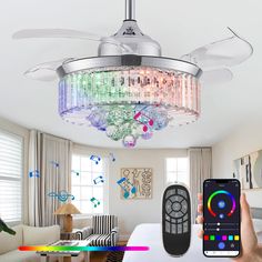 a person holding a remote control in front of a ceiling fan with lights on it