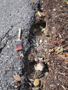 a shovel laying on the side of a road next to some rocks and mulch