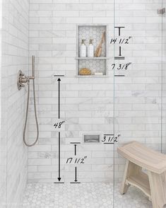 a bathroom with white tile and hexagon tiles on the walls, along with a wooden bench