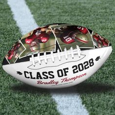 a football sitting on top of a field with the words class of 208 printed on it