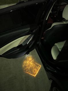 the interior of a car is shown with its door open and light shining on the floor