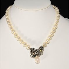 This is part of Chairish’s Costume Jewelry assortment.  Freeform bow necklace by French designer Philippe Ferrandis. Crafted of lustrous faux pearls and rhinestones in gray "black diamond," clear, and milky white. Metal is silver in color. Marked on the back. Adjusts from about 16 to 19.5 inches long; bow measures about 1.75 inches long including the faux pearl dangle and 1.5 inches wide. Formal White Pearl Necklace With Rhinestones, White Pearl Necklace With Rhinestones For Formal Occasions, Elegant Pearl Necklace With Rhinestones For Gift, Silver Pearl Bridal Necklace For Evening, Glamorous Silver Pearl Necklace For Evening, Long Bow, Bow Necklace, French Designer, Milky White