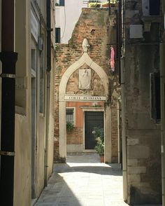 an alley way leading to a building with a clock on it