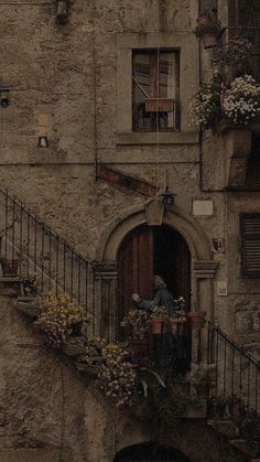 an old building with flowers on the balcony