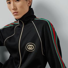 "Find GUCCI Technical Jersey Zip Jacket Ready-to-wear on Editorialist. Mixing a black base with a contrast ribbon detail, this technical jersey zip jacket is imbued with a vintage, sportswear inspired feel and is defined by an easy silhouette. A sporty play on an emblematic logo, the Interlocking G patch enriches the style on the back pocket. Black technical jersey, Interlocking G print, Ribbon detail, Long sleeves, Rib trims, Front zip pockets, Back length: 26,7\", based on size M, Front zip closure, Regular fit, Made in Italy, The product shown in this image is a size small" Gucci Long Sleeve Track Jacket For Winter, Gucci Long Sleeve Track Jacket For Fall, Gucci Casual Track Jacket For Winter, Gucci Casual Winter Track Jacket, Casual Gucci Winter Track Jacket, Casual Long Sleeve Gucci Track Jacket, Gucci Sporty Streetwear Outerwear, Gucci Sporty Outerwear For Streetwear, Sporty Gucci Outerwear For Streetwear