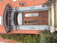 the front door of an old brick building with wrought iron railings and decorative columns