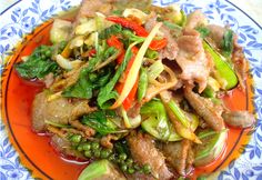 a blue and orange plate topped with meat and vegetables