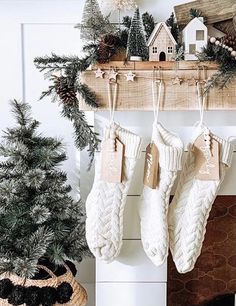 stockings hanging from a mantel with christmas decorations