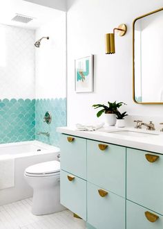 a bathroom with blue and white tiles on the walls, two sinks, a toilet and a bathtub