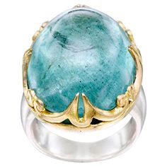 A lively green-blue large 18 x 24 mm oval cabochon aquamarine is held is a sculpted and spiraled carved 18K gold bezel atop a wide matte-finish sterling shank in this eye-catching design. Very noticeable and unique. Currently sized 7. This ring is resizable. Some lucky buyer will love this ring! Wax Casting, Lost Wax Casting, 3 Carat, Oval Cabochon, Cocktail Rings, Aquamarine, Silver Ring, Silver Gold, Blue Green