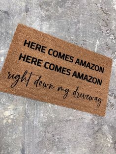 a door mat that says here comes amazon here comes amazon right down my driveway on concrete