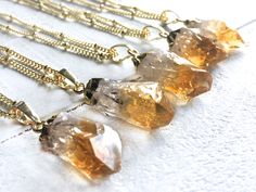 "Gorgeous raw citrine crystals dipped in gold plating! Each dainty crystal measures approximately 3/4\" - 1\" long (see model for size reference). Chains are available in your choice of length: 16\" for an extra short length, 18\" for a standard length, or 20\" for extra length (Model is wearing 18\"). You may also choose your chain finish: Real 14K Gold filled or Gold plated. Finally, you may choose your chain style. All chains are shown in the 3rd photo. Necklace comes in a custom gift pouch, Gold Citrine Gemstone Crystal Necklace, Gold Citrine Gemstone Crystal Necklaces, Gold Citrine Necklace For Healing, Gold Dainty Crystal Necklace For Healing, Gold Citrine Pendant Crystal Necklace, Healing Gold Crystal Necklaces, Healing Crystals Necklace, Angel Aura Quartz Necklaces, Raw Citrine Necklace