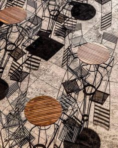 many chairs and tables are arranged together on the ground, with shadows cast on them