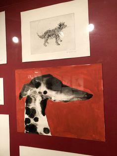 a painting of a dalmatian dog on a red wall next to two framed pictures