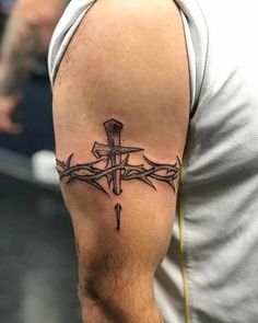 a man with a cross tattoo on his arm