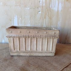 a white planter sitting on top of a burloom floor next to a wall