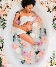 a woman in a bathtub surrounded by flowers