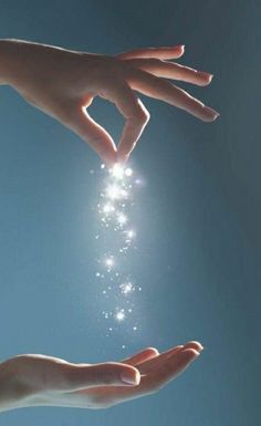 two hands reaching out towards each other to touch the stars in the sky above them