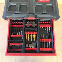 a tool box filled with tools on top of a wooden floor