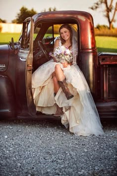 a woman sitting in the back of an old truck wearing a wedding dress and cowboy boots