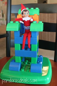 an elf is sitting on top of a building made out of legos and blocks