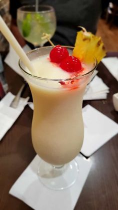 a glass filled with liquid and topped with a cherries garnish