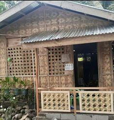 a small wooden house with a metal roof and decorative screens on the front door,