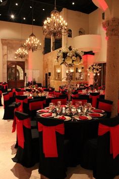 a banquet room set up with black and red linens