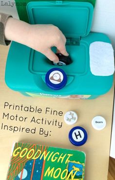 a child's hand is pressing buttons on a blue box with the words printable fine motor activity inspired by goodnight moon